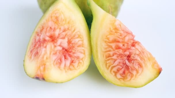 Juicy, ripe, green-yellow figs, whole and slices, on a white background. Close. Food concept. Slow rotation. — Stock Video