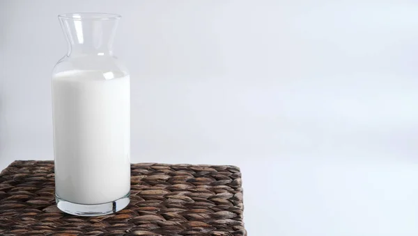 Milk in a glass bottle stands on a wicker box