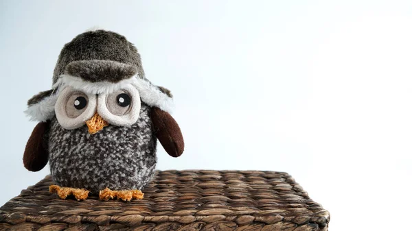 Toy owl sitting on a wicker box
