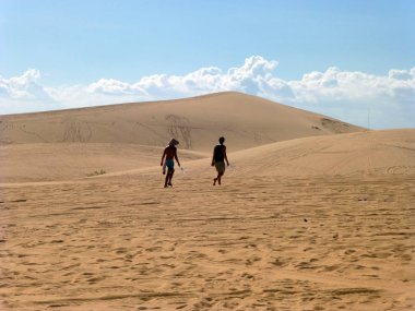İki kişi Sands üzerinde yürümek. Çöl mavi gökyüzü arka plan üzerinde