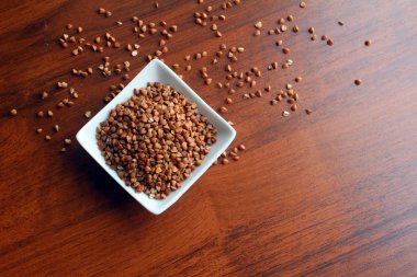 Beyaz kase ahşap bir masa üzerinde buğday taneleri ile ana sayfa görünümü.