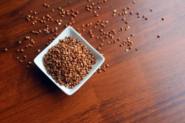 Beyaz kase ahşap bir masa üzerinde buğday taneleri ile ana sayfa görünümü.