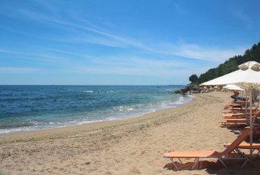 Beyaz plaj şemsiye ve şezlong güneşli havalarda güzel denizde. Parlak yaz 