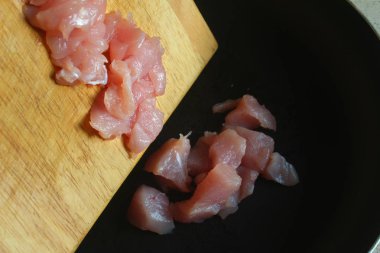 Doğranmış tavuk. siyah bir tavada et kayması kesilmiş parçaları.