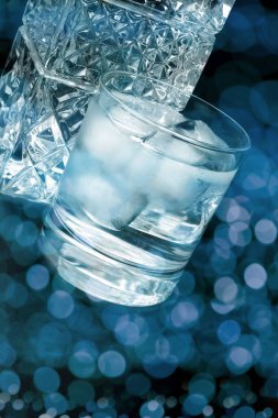 Siyah arka planda kristal viski bardağı ve şişe