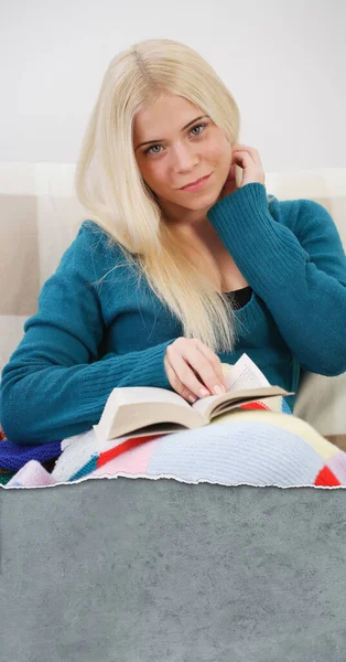 ソファに座って読書をしている女性 — ストック写真