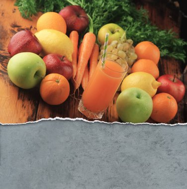 Taze meyve suyu bardakta, meyvelerle çevrili.