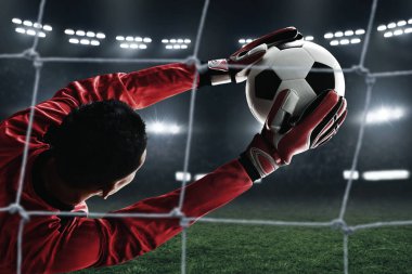 Futbol kalecisi topu yakalıyor.