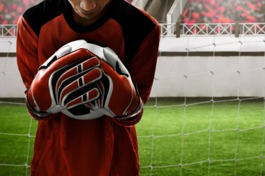 Futbol kalecisi topu yakalıyor.