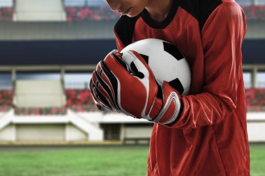 Futbol kalecisi topu yakalıyor.