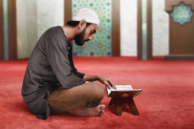 Müslüman adam Kuran okuyor.