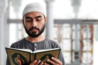 Müslüman adam Kuran okuyor.