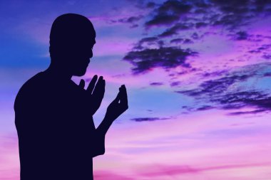 Müslüman adamın silueti dua ediyor.