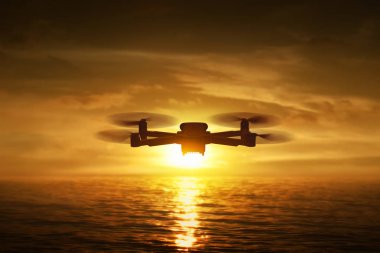 Dron kuadkopteri gün batımında uçuyor.