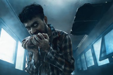 Lanetli evde çiğ et yiyen korkunç zombi adam, Cadılar Bayramı teması.