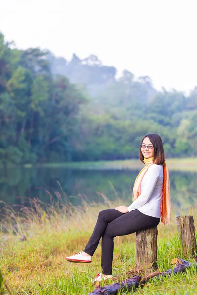Азиатка, сидящая у озера . — стоковое фото