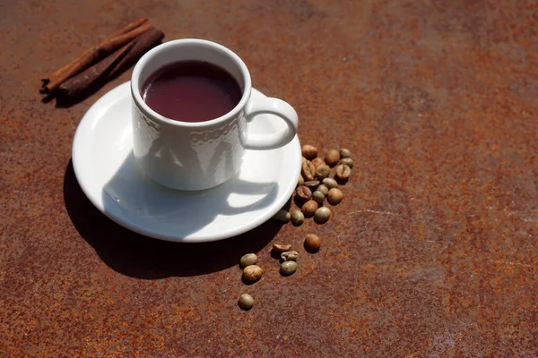 Flat lay Coffee composition  with  white cup  of red coffee and beans of coffe on iron  rustic background