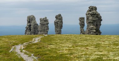 Manpupuner rock formations. Weathered stone pillars. Famous nature landmark of Ural mountains, Komi Republic, Russia. Travel destination landscape. clipart