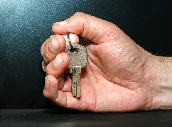 Hand with keys on a dark background