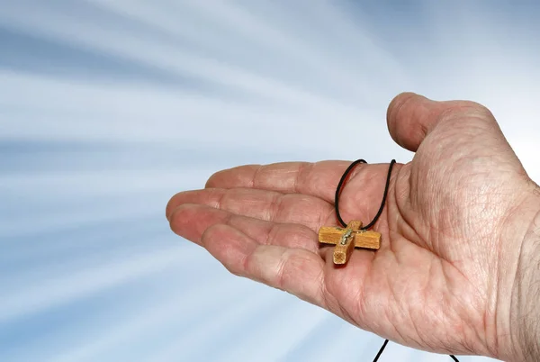 Mão com uma cruz de madeira — Fotografia de Stock