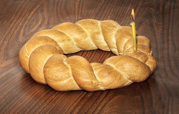 Плетеный хлеб и горящая свеча — стоковое фото