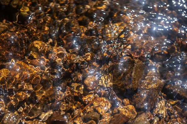 乌黑的河水 溅满水花 闪烁着石光 — 图库照片