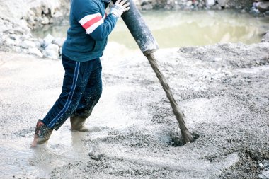 Pompa tüpüyle çimento ya da beton döken inşaat işçisi