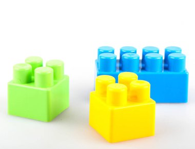 Beyaz arkaplanda plastik renkli oyuncak blokları