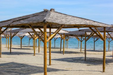 Boş plajda kum şemsiyeler