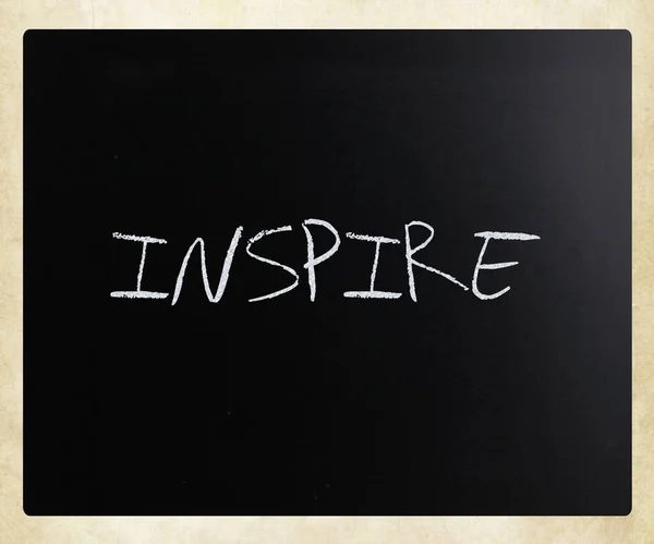 "Inspire "handwritten with white chalk on a blackboard — стоковое фото