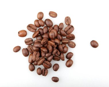 Taze kavrulmuş kahve çekirdekleri beyaz arka planda izole edildi.