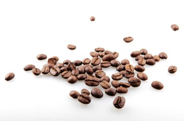 Taze kavrulmuş kahve çekirdekleri beyaz arka planda izole edildi.