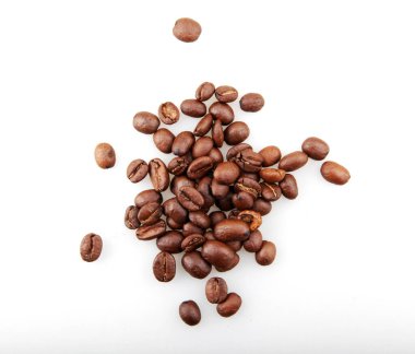 Taze kavrulmuş kahve çekirdekleri beyaz arka planda izole edildi.