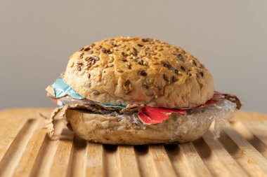 Taze lezzetli burger plastik atık ve ahşap tahta üzerinde kağıt karton içinde. Bizim gıda kavramı geri dönüşümlü atık