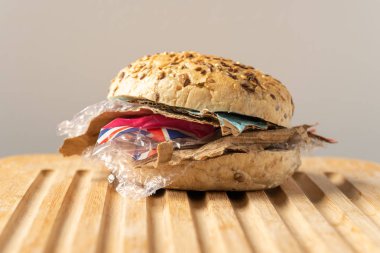 Taze lezzetli burger plastik atık ve ahşap tahta üzerinde kağıt karton içinde. Bizim gıda kavramı geri dönüşümlü atık