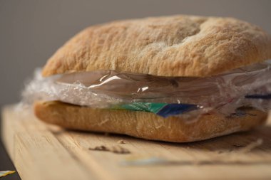 Plastik atık ve ahşap tahta üzerinde içinde kağıt karton ile taze lezzetli panini sandviç. Bizim gıda kavramı geri dönüşümlü atık