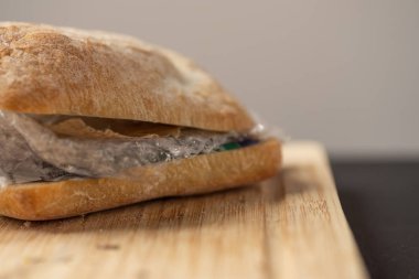 Plastik atık ve ahşap tahta üzerinde içinde kağıt karton ile taze lezzetli panini sandviç. Bizim gıda kavramı geri dönüşümlü atık