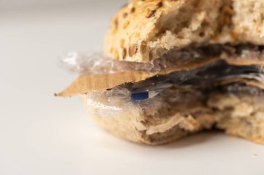 Burger taze lezzetli payını panini plastik atık ve beyaz arka plan üzerinde içinde karton kağıt. Bizim gıda kavramı geri dönüşümlü atık