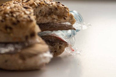 Burger taze lezzetli payını panini plastik atık ve beyaz arka plan üzerinde içinde karton kağıt. Bizim gıda kavramı geri dönüşümlü atık