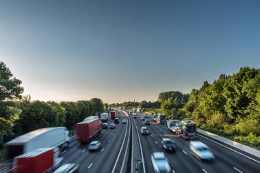 Sunset view heavy traffic moving at speed on UK motorway in England clipart