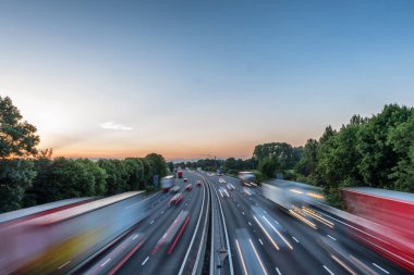 Sunset view heavy traffic moving at speed on UK motorway in England clipart