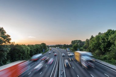 Sunset view heavy traffic moving at speed on UK motorway in England clipart