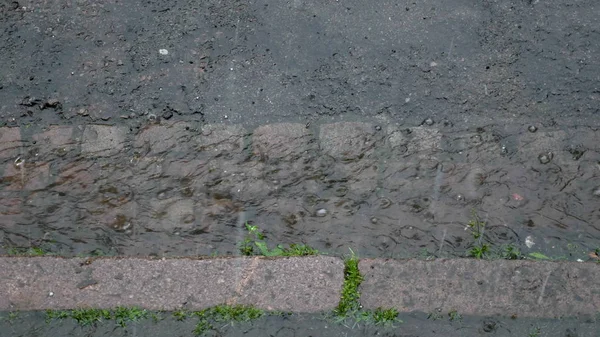 Large rain drops and hailstones strike road surface during heavy shower in England — Stock Photo, Image