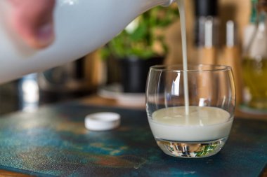 El yağan taze kefir probiotik suya beyaz şişe açık cam mutfak masasında