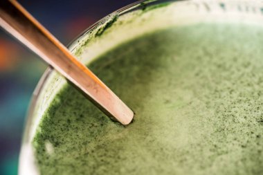 Mutfak masasının üzerinde yeşil spirulina tozu ile portre görünümü taze kefir probiotik içki açık cam içinde karışık
