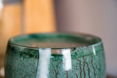 Closeup görünümü cam mutfak masasının üzerinde yeşil spirulina tozu ile karışık taze kefir probiotik içeceği boşalttı