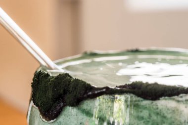 Mutfak masasının üzerinde yeşil spirulina tozu ile portre görünümü taze kefir probiotik içki açık cam içinde karışık