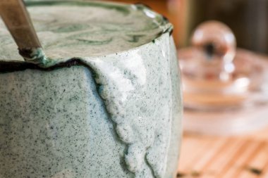 Mutfak masasının üzerinde yeşil spirulina tozu ile portre görünümü taze kefir probiotik içki açık cam içinde karışık