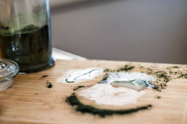Closeup görünümü taze kefir probiotik içki ve yeşil spirulina tozu artık yemek mutfak masasının üstünde karıştırma sonra ahşap tahta üzerinde