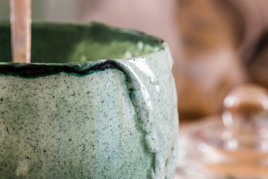 Closeup görünümü cam mutfak masasının üzerinde ahşap tahta üzerinde yeşil spirulina tozu ile karışık taze kefir probiotik içeceği boşalttı